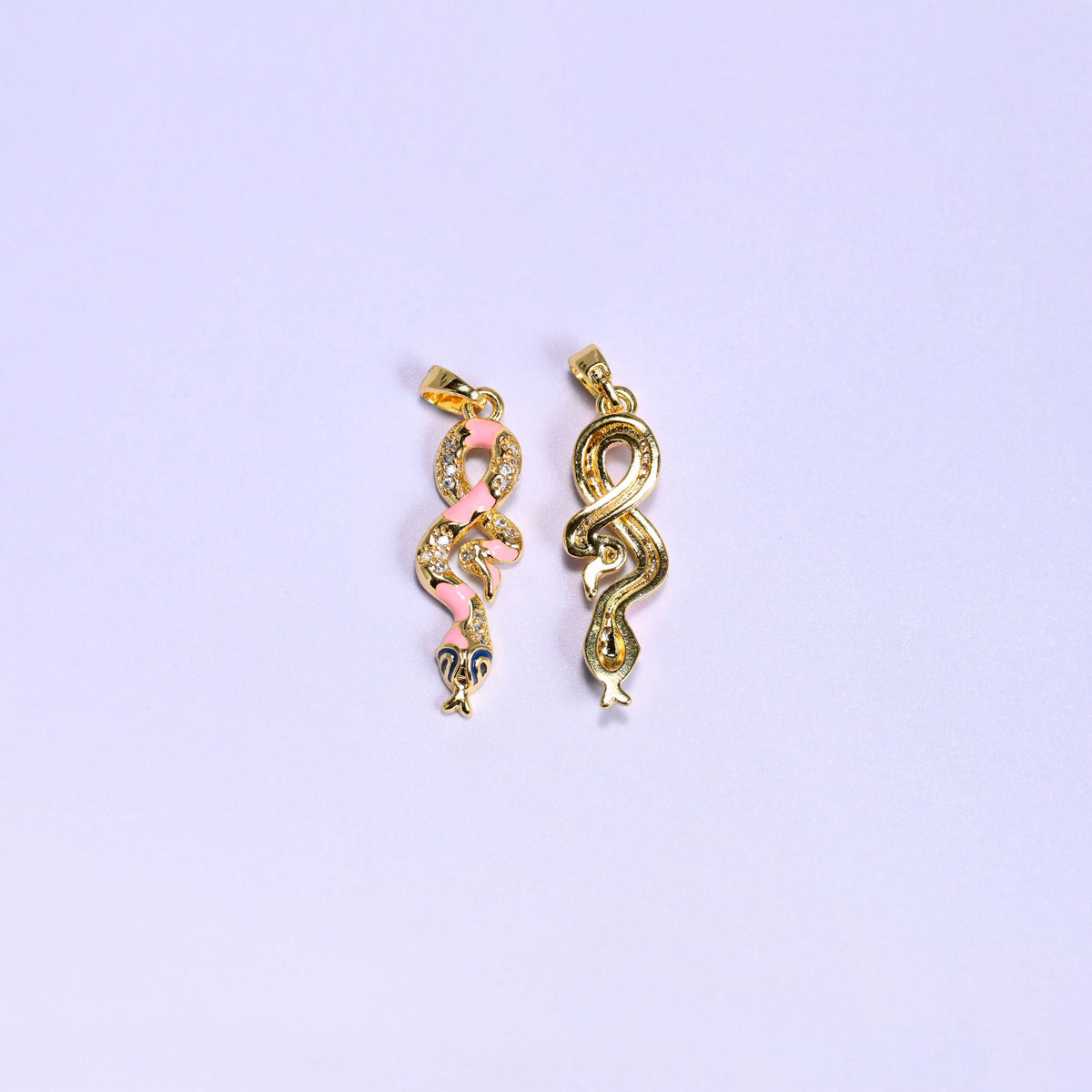 Front and reverse of the Enamel Snake Zirconia Charm, pink enamel and zirconia pave on the left and the smooth gold back of the coiled snake on the right.