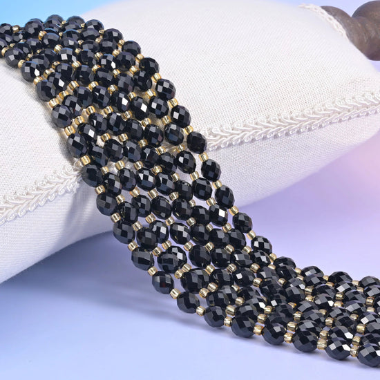 Black Onyx Faceted Rice Barrel Beads, deep opaque black barrels with facets cut in tight rows around the middle.