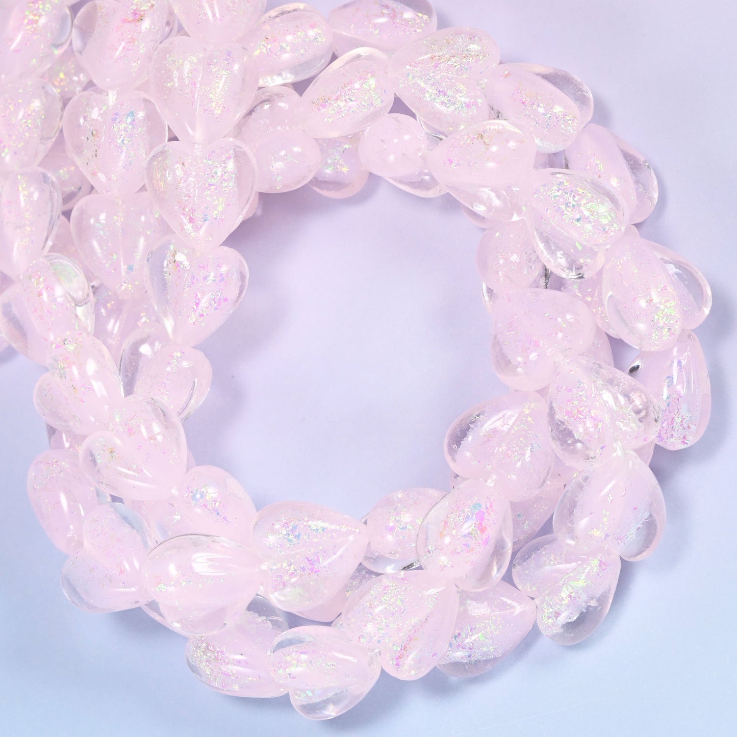Milky pale pink hearts with a frosted, almost opalescent surface that lifts into soft rainbow shimmer