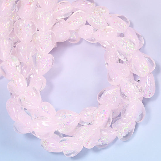 Milky pale pink hearts with a frosted, almost opalescent surface that lifts into soft rainbow shimmer