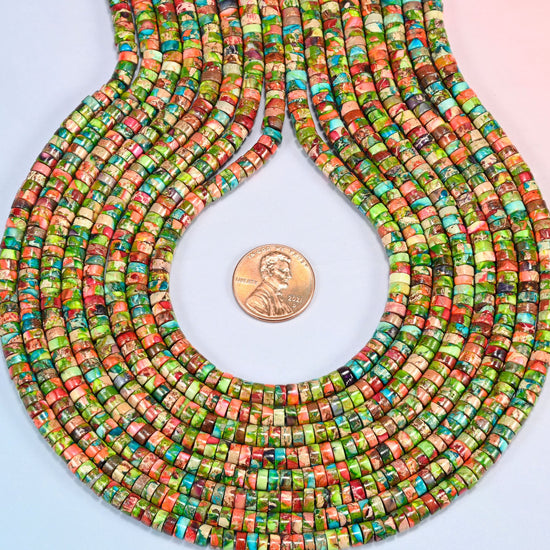 Dyed blue green sea sediment jasper heishi disc strands formed into a teardrop loop around a US penny for scale