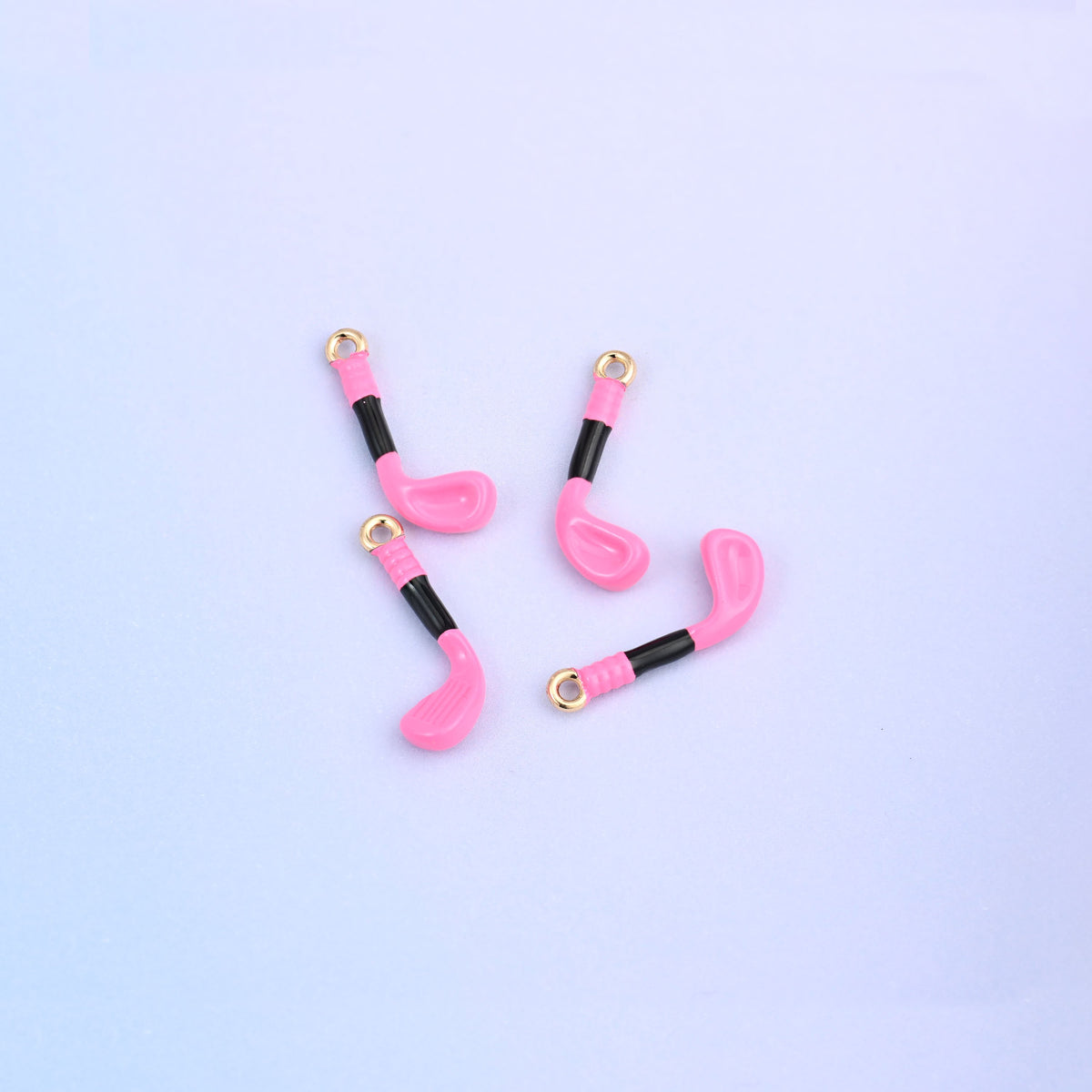 Four pink golf club charms with black enamel grips.