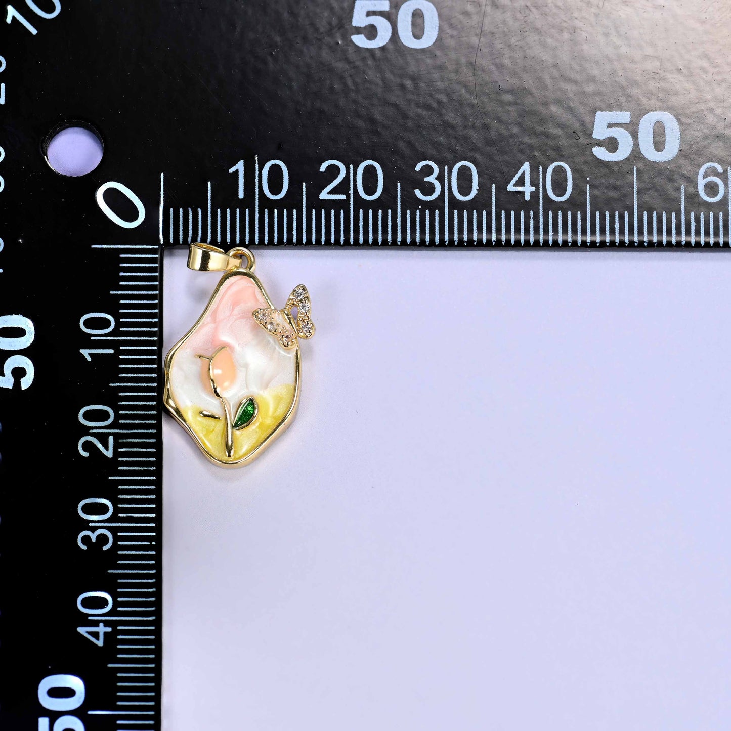 18K gold plated brass tulip butterfly charm pendant with a soft pink and yellow enamel tulip, a green leaf accent, and a sparkling clear zirconia butterfly in a freeform frame.
