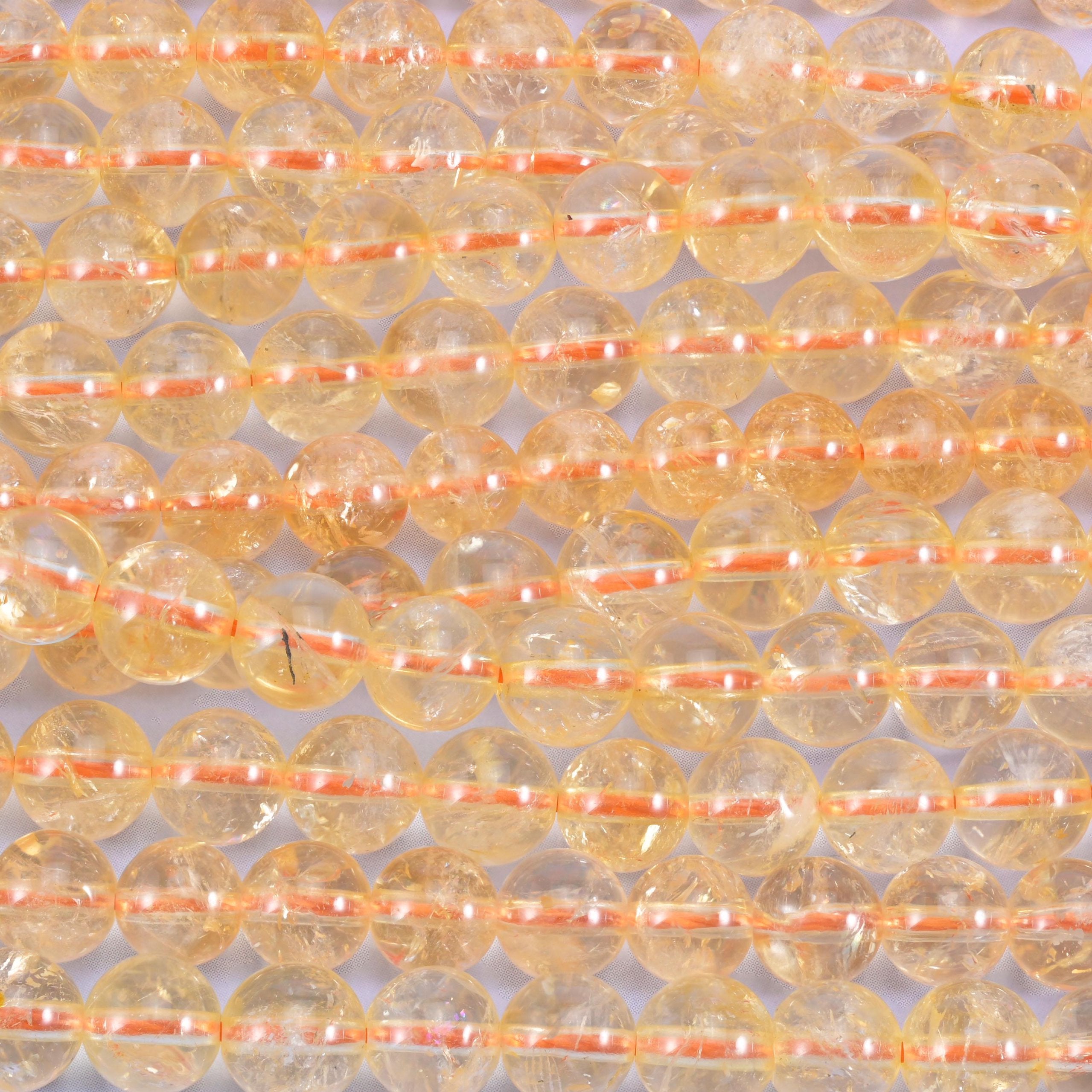 Pale champagne-gold rounds, translucent enough to glow when light comes through them, with fine milky veils and feathering set inside the stone
