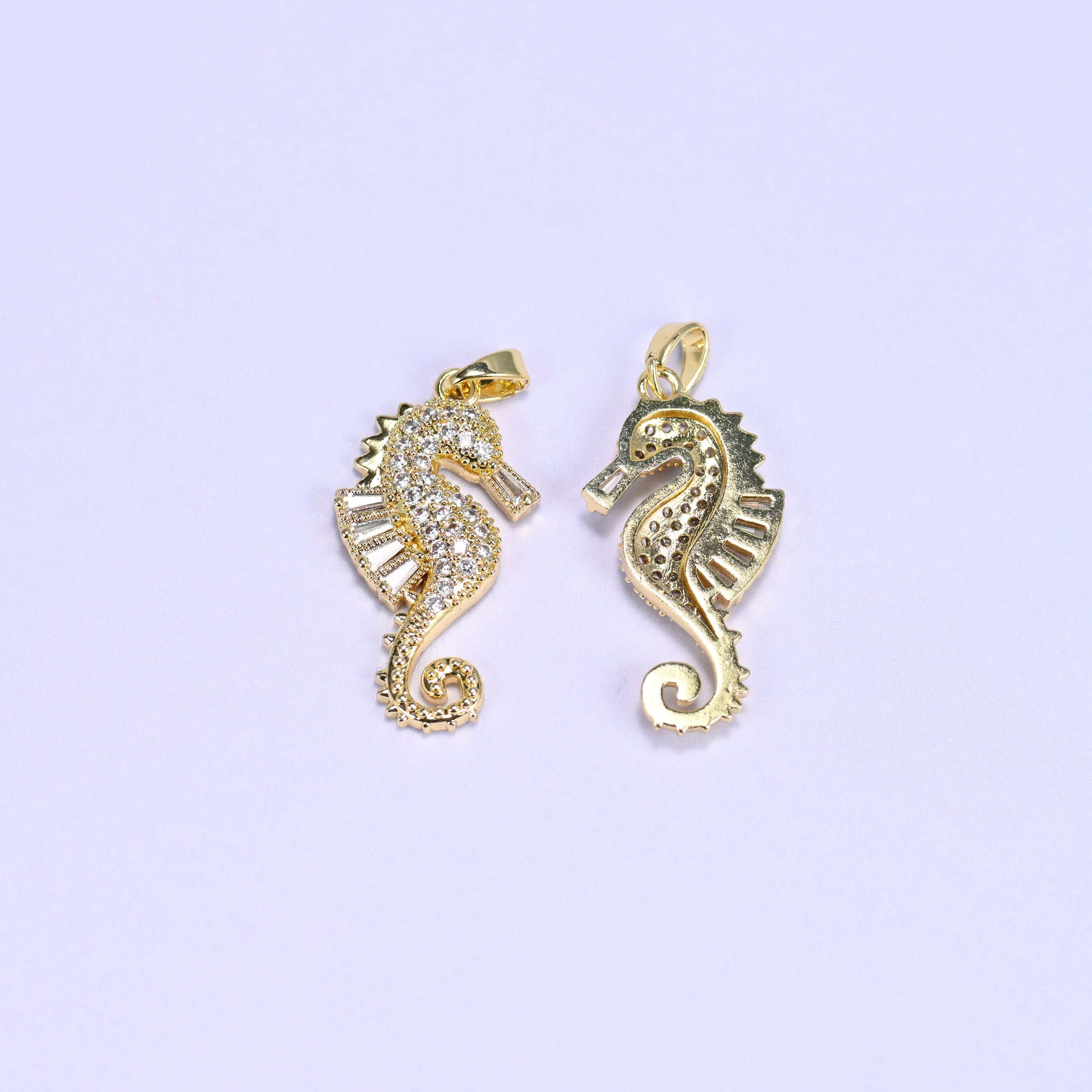 Gold sea horse zirconia charm shown front and back, one pendant paved in clear zirconia and one flipped to the plain gold side.