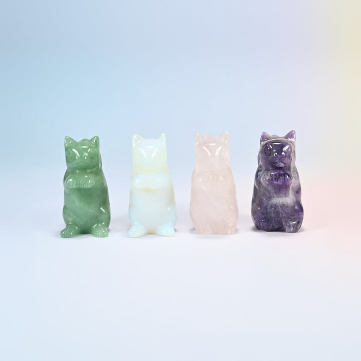 Front view of four squirrel carvings: natural green aventurine, opalite, natural rose quartz and natural amethyst, paws held up