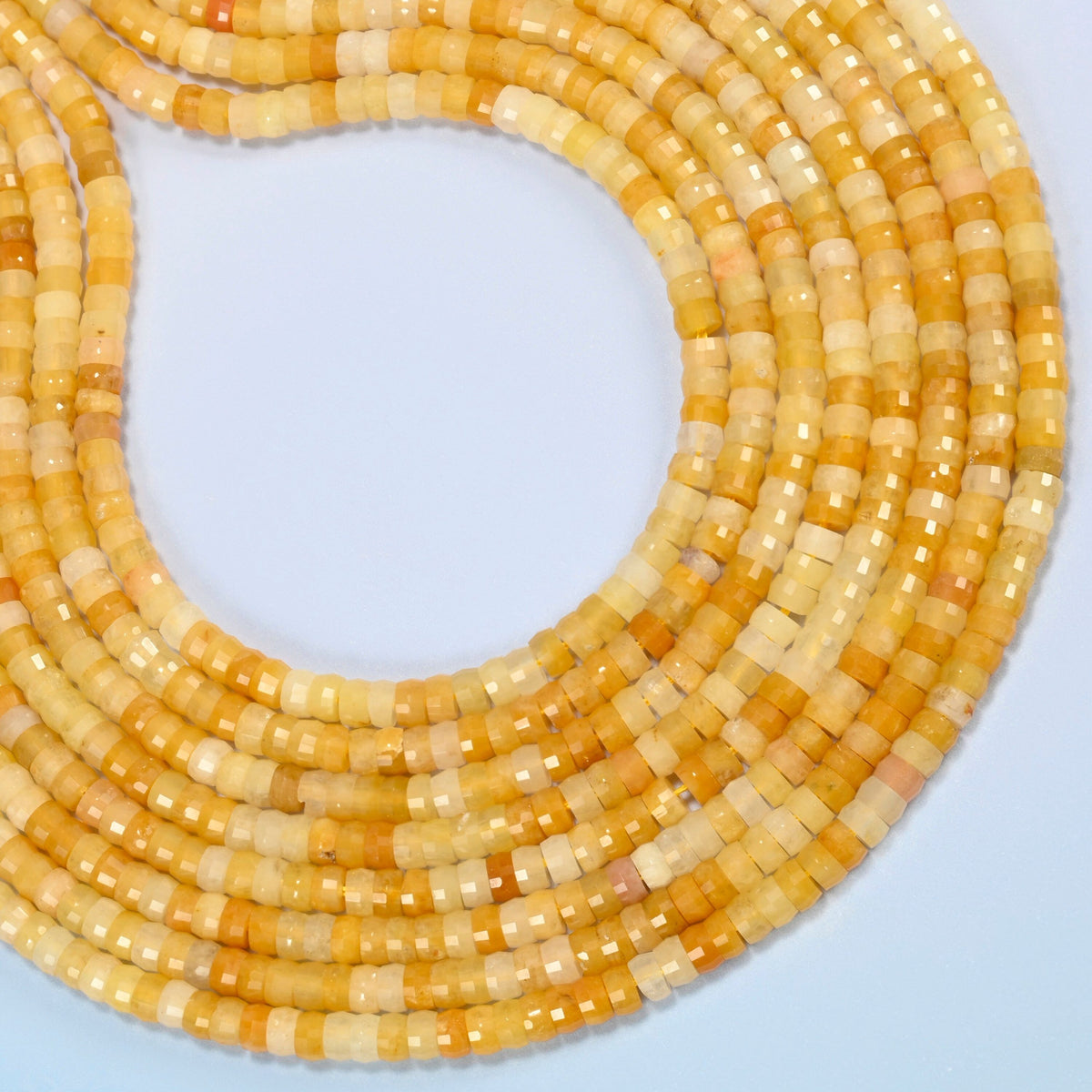 Gold Silk Jade faceted heishi disc beads curved into an open loop, golden yellow, honey and cream beads