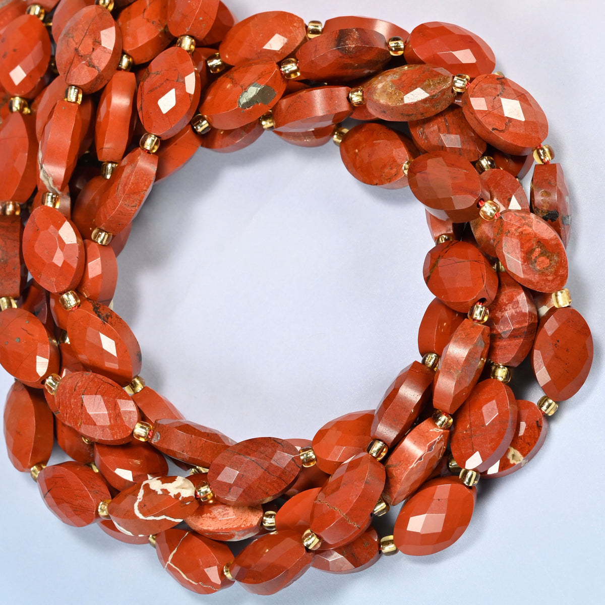 Flower red jasper faceted flat oval beads coiled into overlapping loops, whole strands of brick red and cream stone