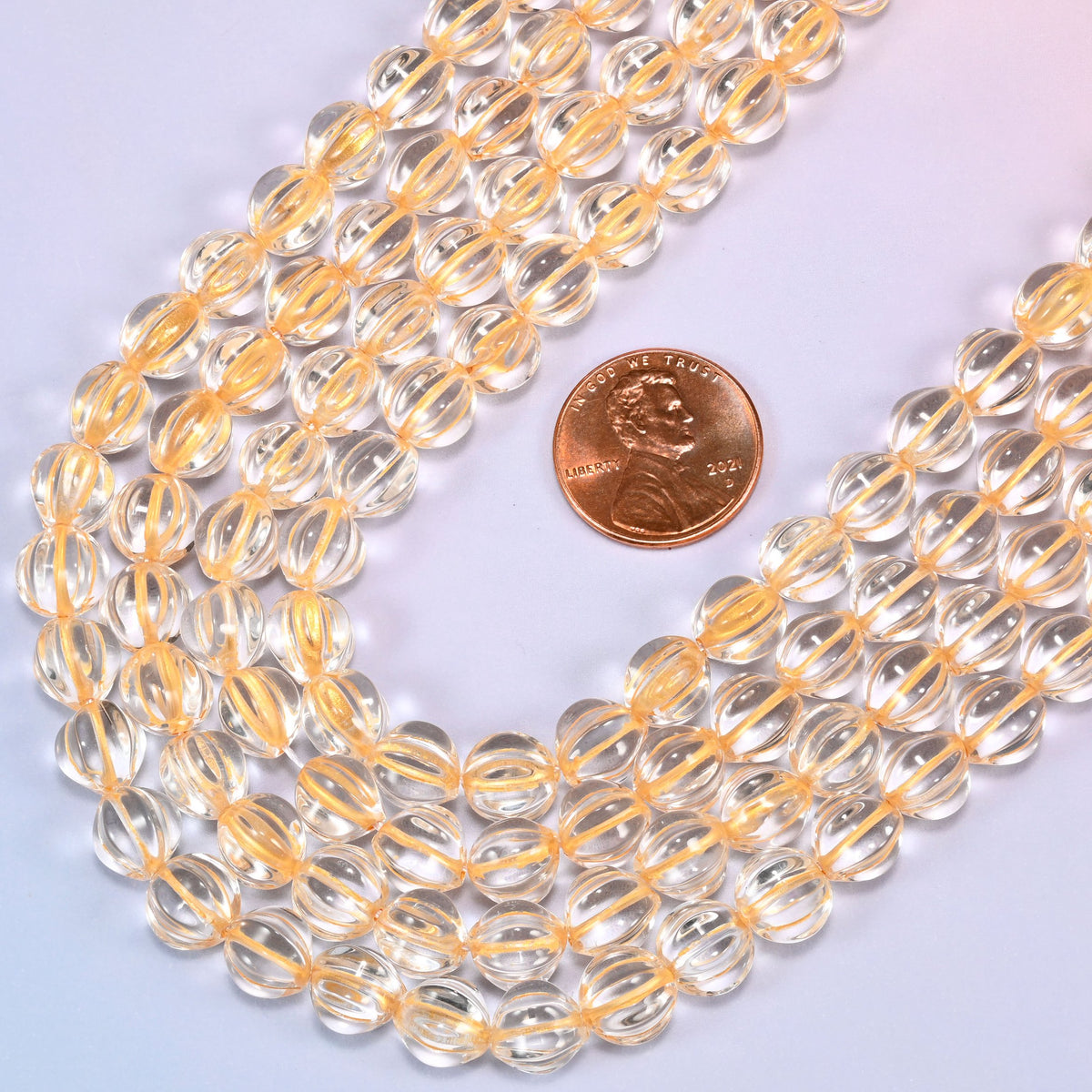 Clear gold pumpkin glass beads coiled into a wide open ring, gold ribs catching the light.