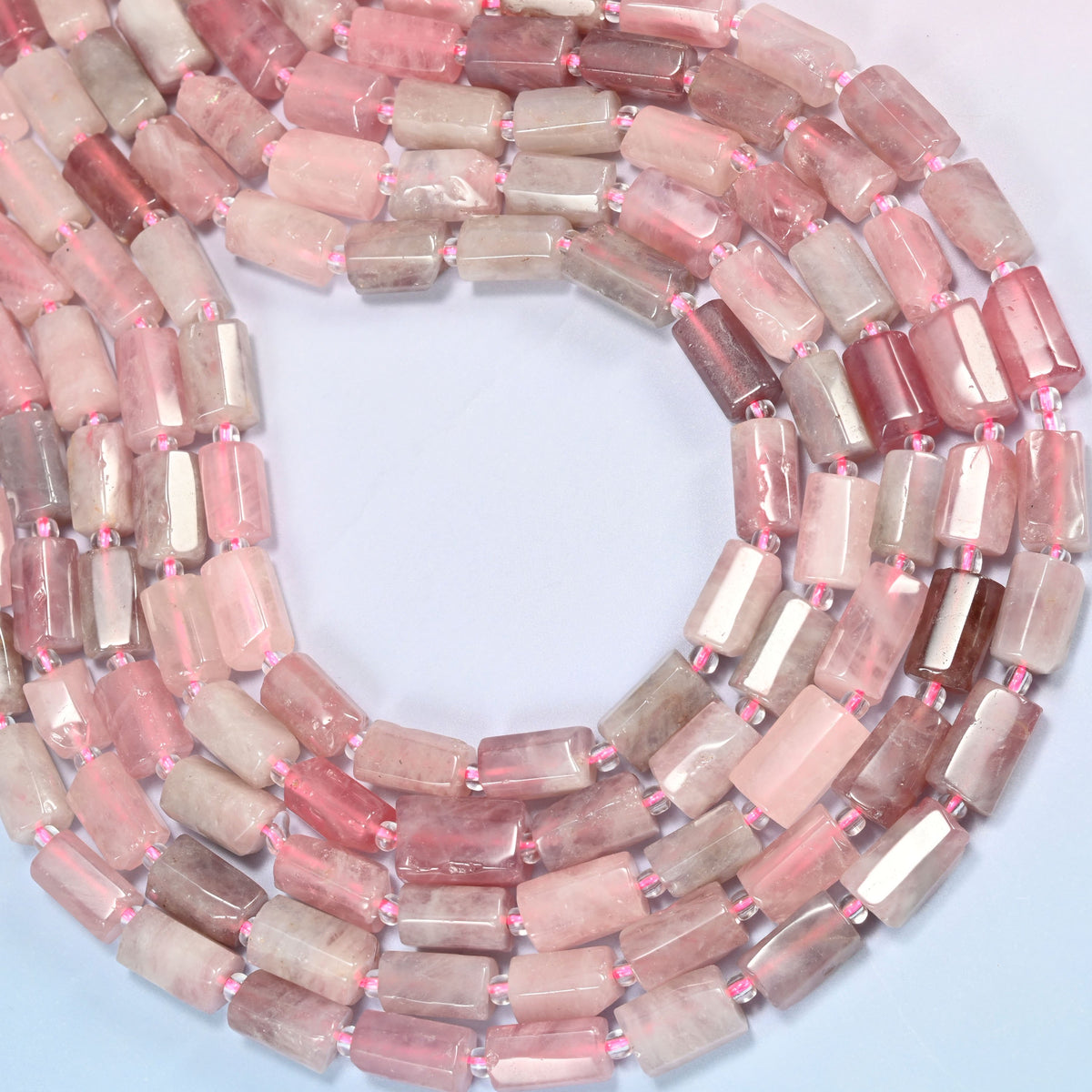 Madagascar multi color rose quartz faceted tube beads wound into an open coil, blush, mauve and wine toned tubes mixed.