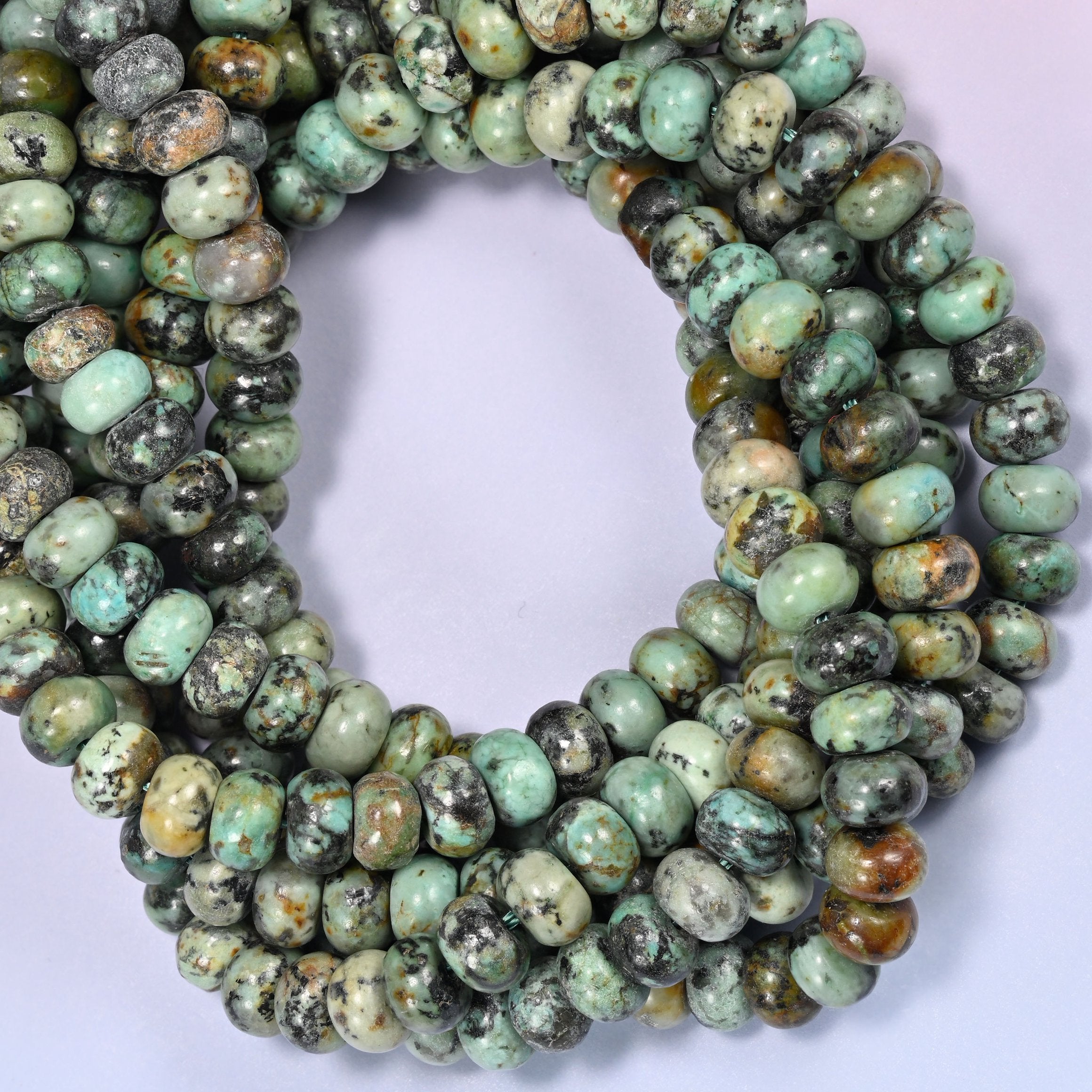 Close-up horizontal row of African Howlite beads showing the green and brown stone pattern.