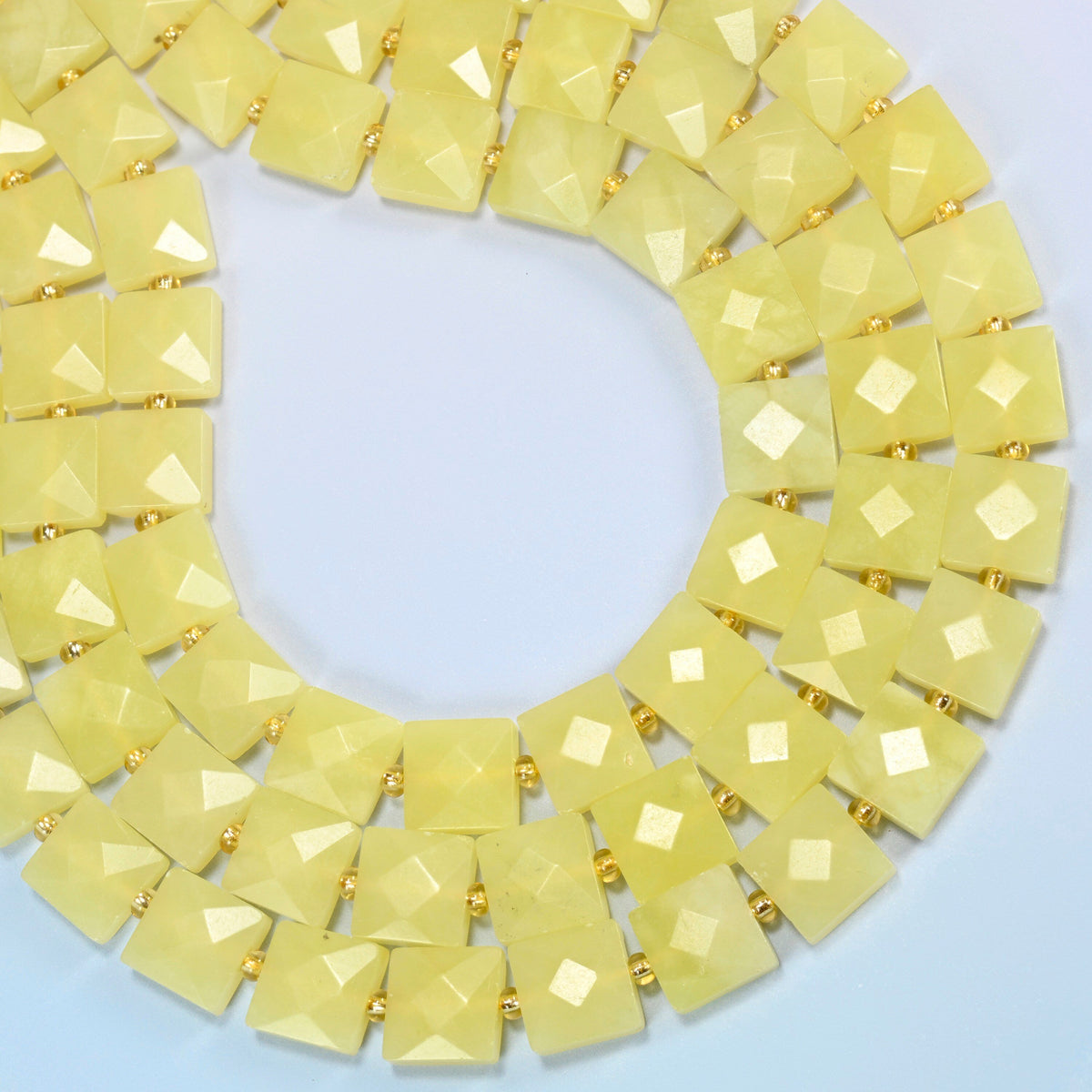 Lemon Jade faceted flat square beads curved into an open loop, light lemon yellow beads