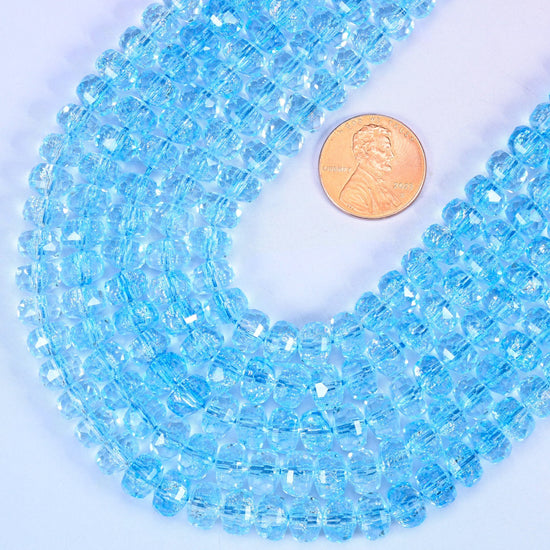 Faceted rondelle cut transparent blue glass beads