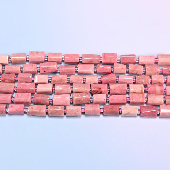 Side view of Pink Rhodonite faceted tube beads laid straight in two rows, showing the flat polished planes and short irregular lengths