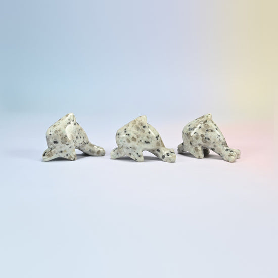 Three kiwi jasper dolphin crystal carvings, cream and light green natural stone with dark spots