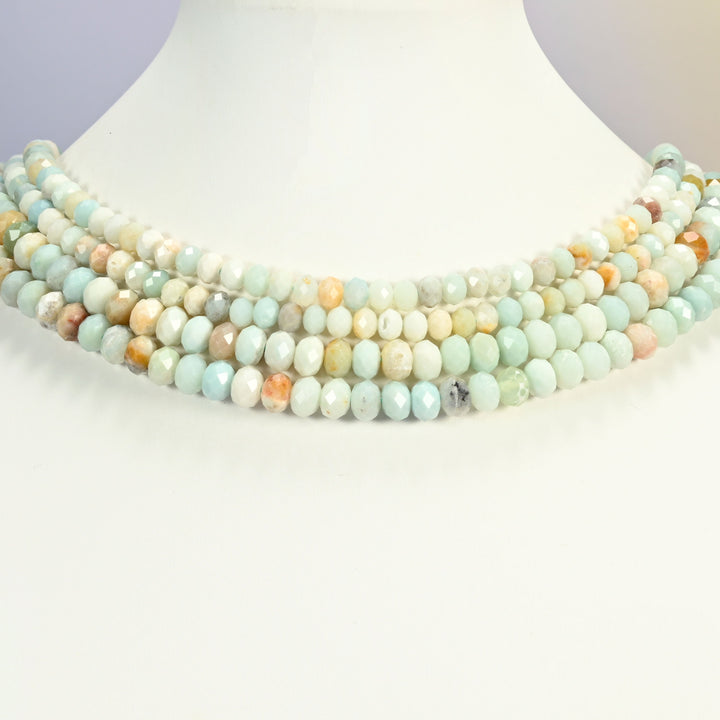 Amazonite beads shown on a white neck display bust, the faceted rondelle strands sitting in even rows against the curve of the neck