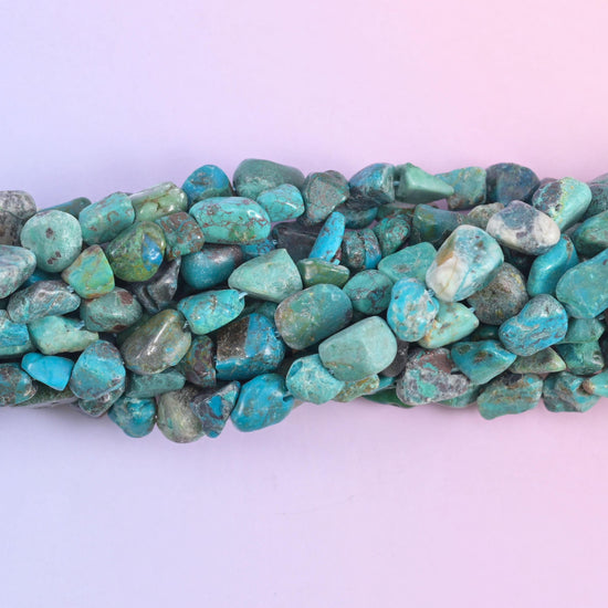 Macro of the nugget faces, sea green stone crossed by charcoal and rust veining