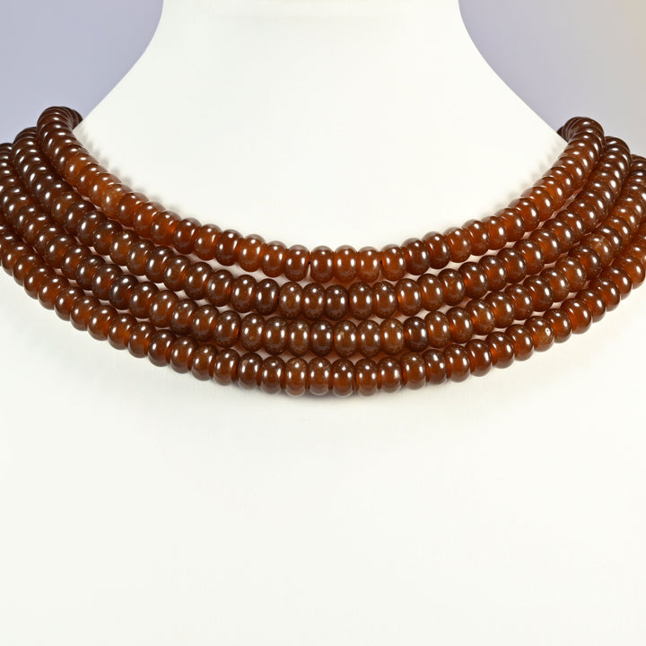 Chestnut Brown dyed jade gemstone rondelle beads shown on a display bust as a layered collar, several strands stepping down in a row