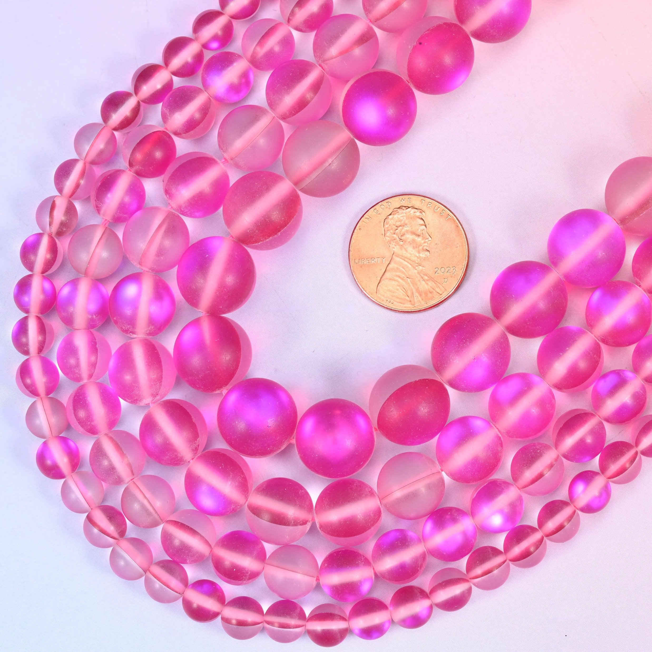 Round matte frosted raspberry-pink glass beads with iridescent coating