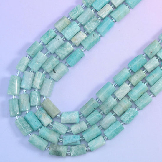 Two strands of blue amazonite tubes falling in a V, showing the flat faceted sides of each bead