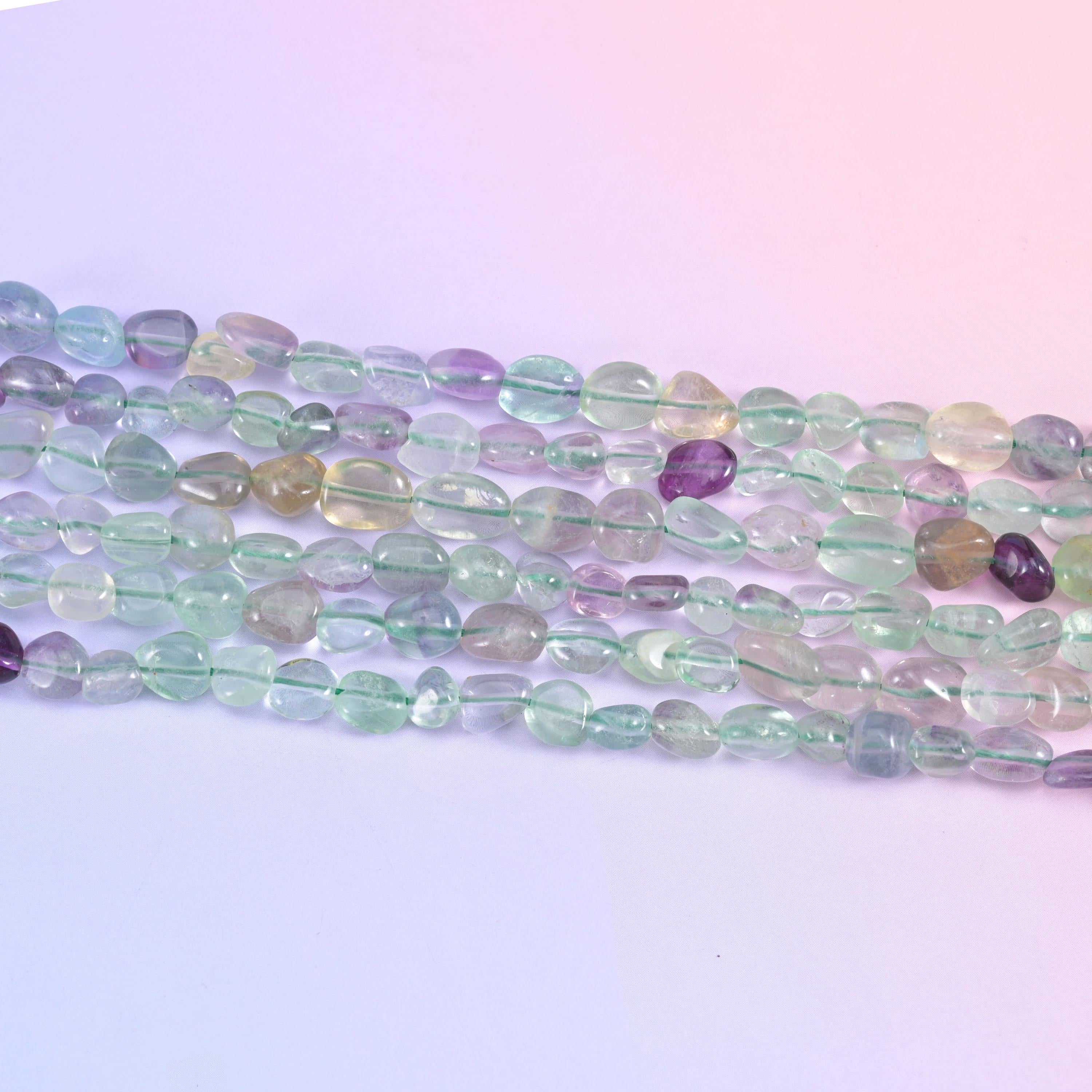 Row of translucent fluorite nuggets in pale green, clear and grape purple