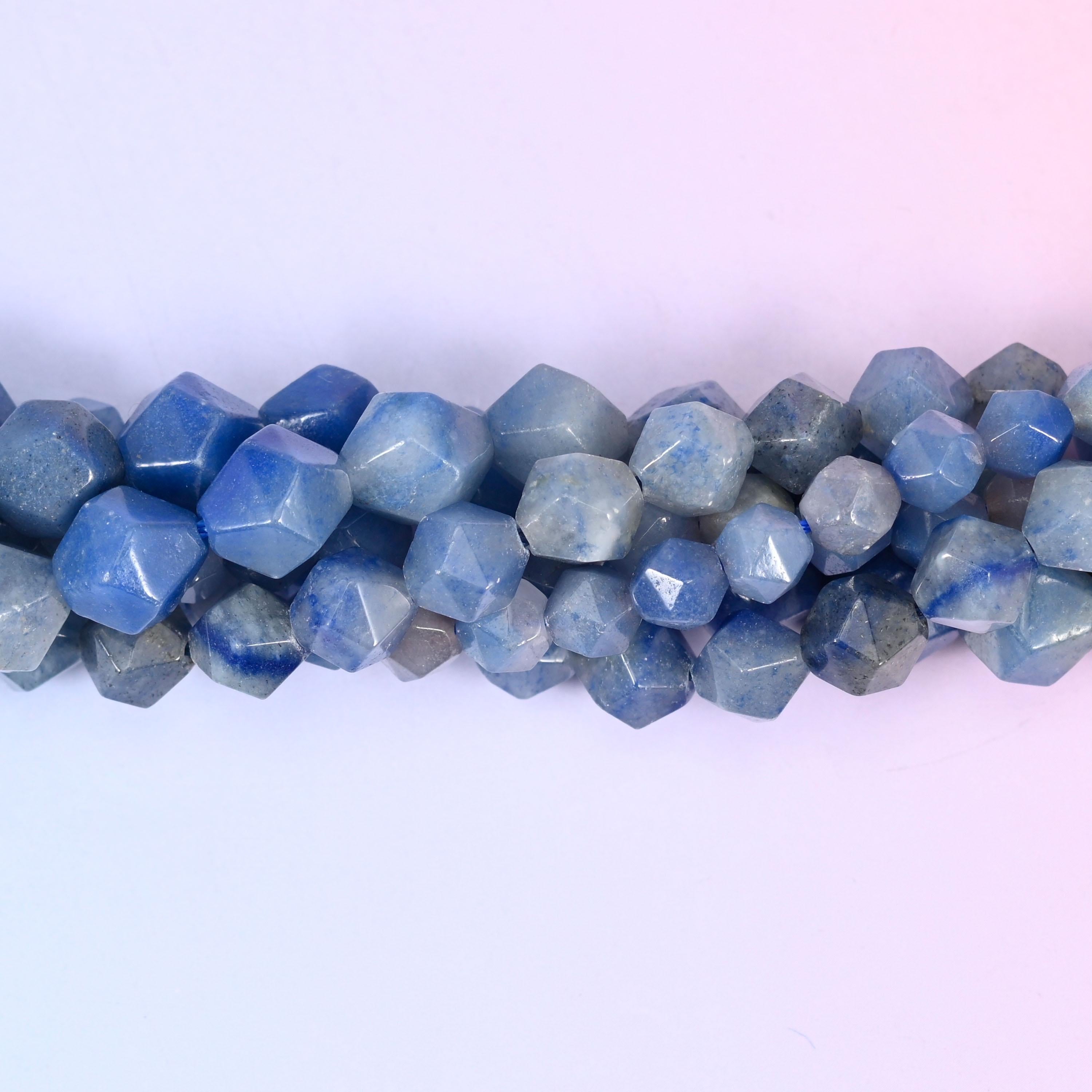 Denim and slate blue beads cut into faceted star shapes, the darker ones nearly navy, the paler ones a soft dusty blue-grey — the stone itself is quietly matte