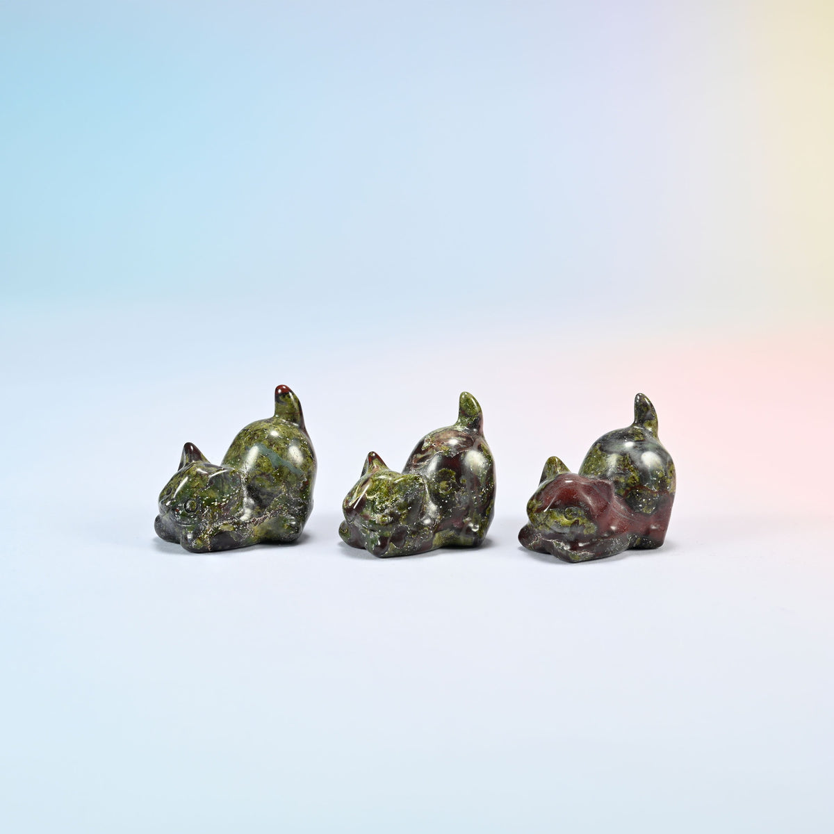 Three natural dragon bloodstone yoga cat carvings side by side, mossy green with red spots, each pattern different