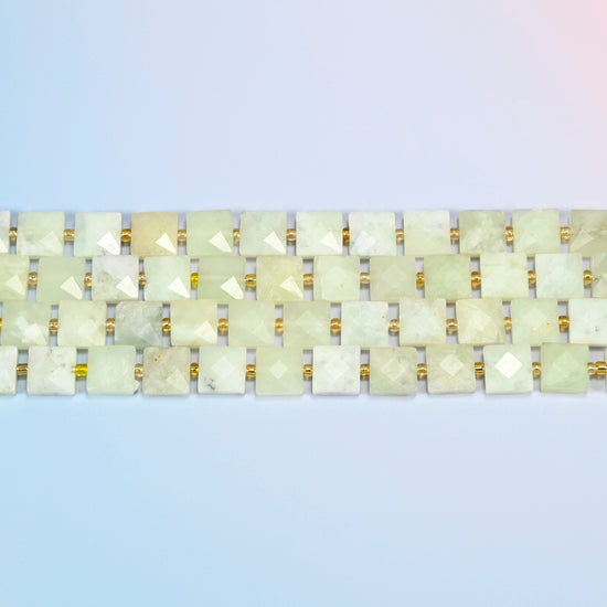 Several strands of New Jade faceted flat square beads laid in straight rows