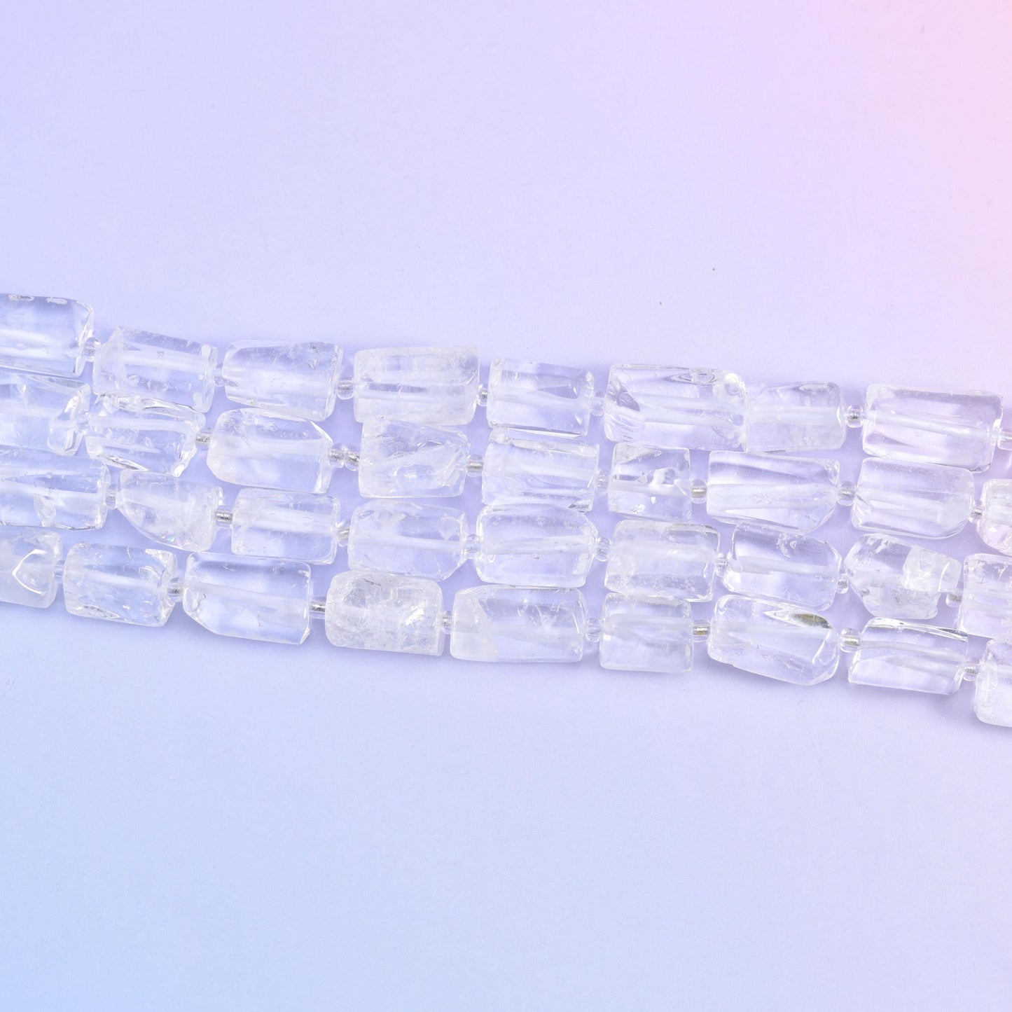 Three strands running diagonally on pale lilac, each tube showing its flat cut faces and internal veils