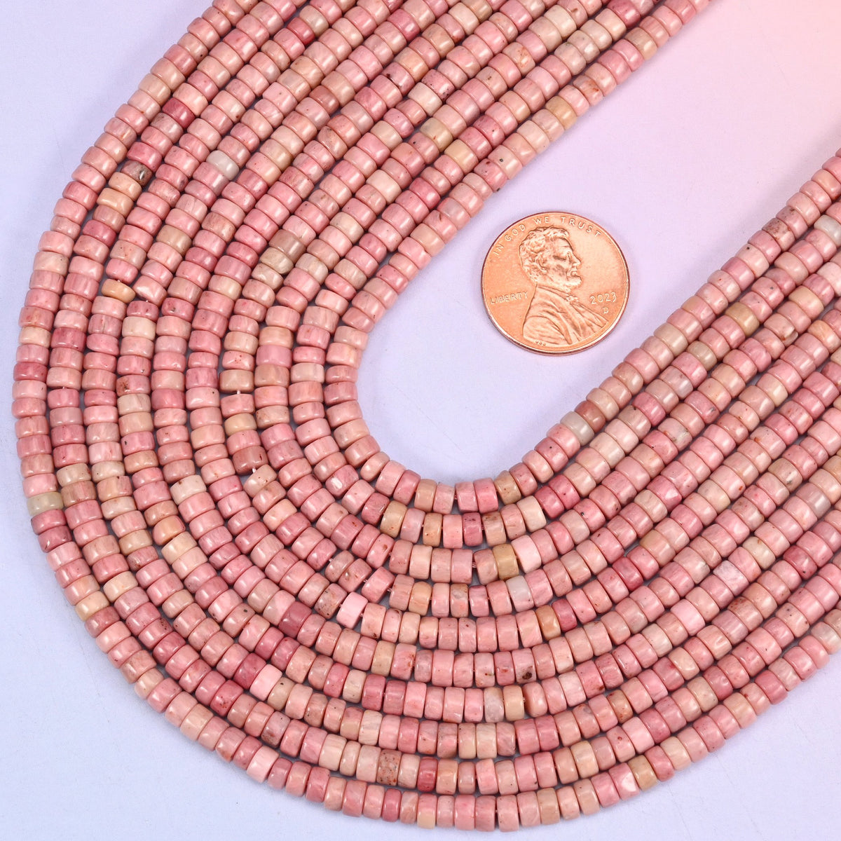 Smooth heishi disc cut pink rhodonite beads for jewelry making.