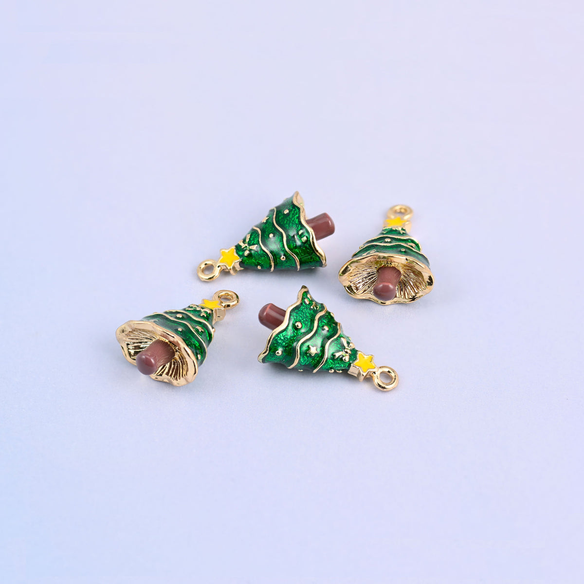 Four christmas tree charms at different angles, showing the 8mm thick three dimensional fir shape.