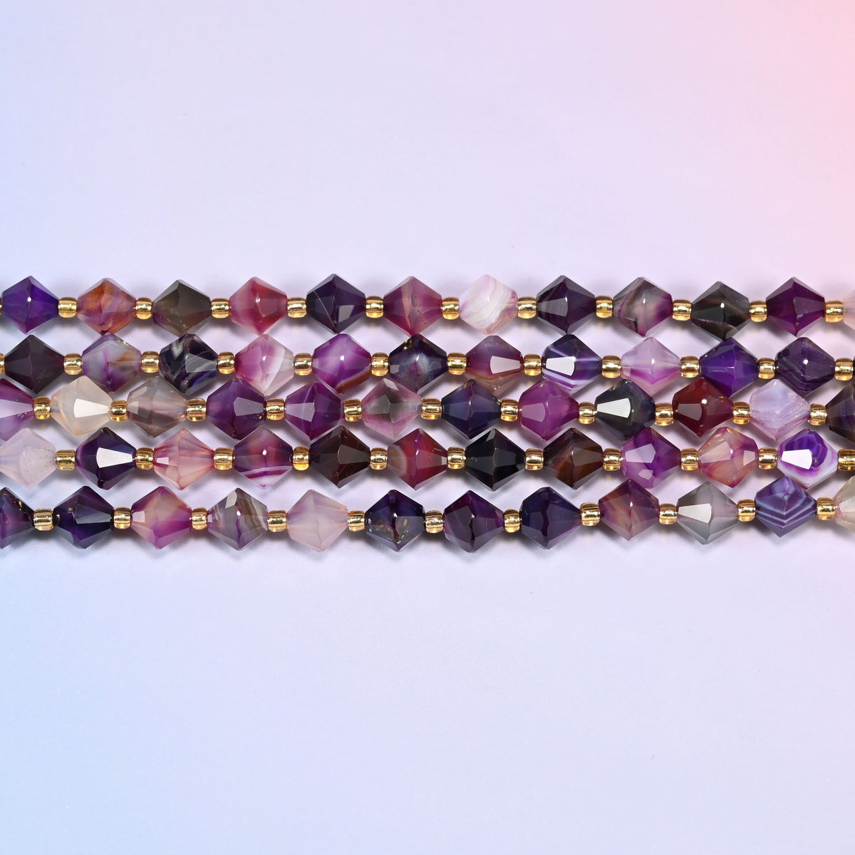 A single straight strand of 8mm Dyed Purple Strip Agate faceted bicone beads laid flat, showing the full 15 inch length.