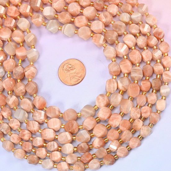 Orange Sunstone Faceted Spiral Twist Beads, a warm peach-to-apricot stone with pale cream streaking