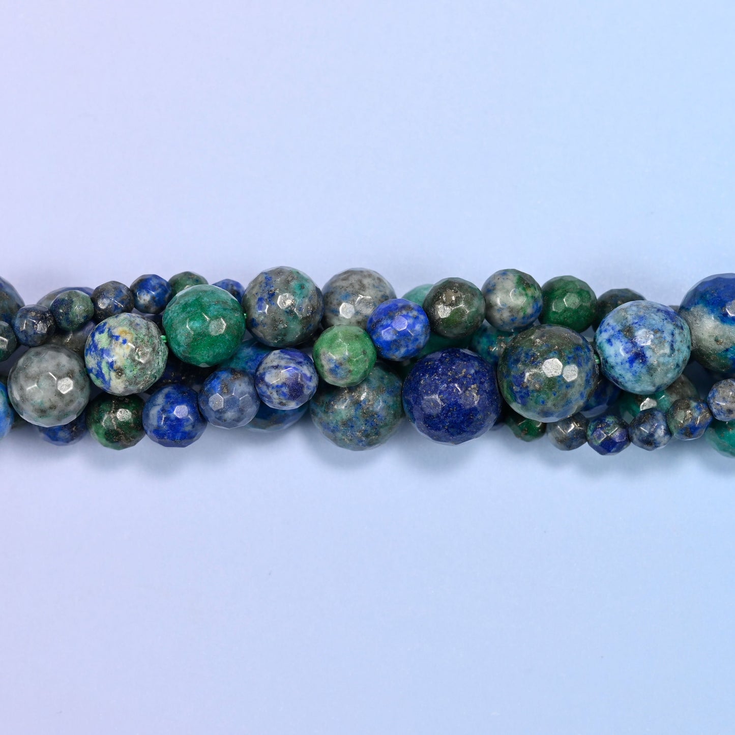 Phoenix Lapis Faceted Round Beads, deep navy blue pooled against jade and teal green with a grey-brown matrix