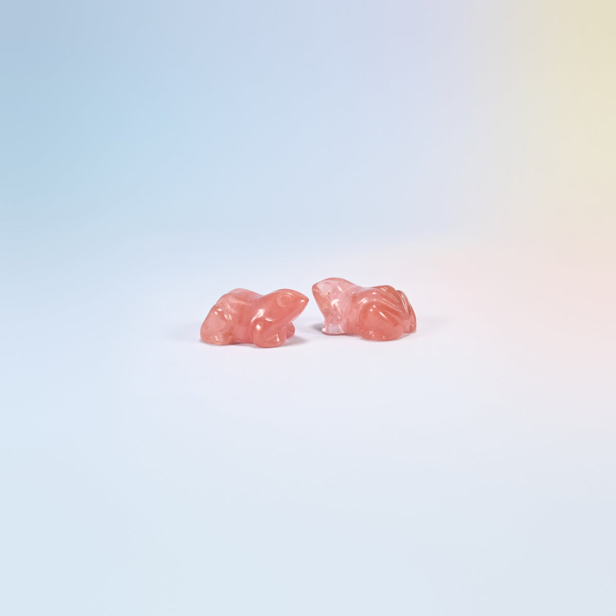 Two cherry quartz frog carvings, bright pink man-made glass