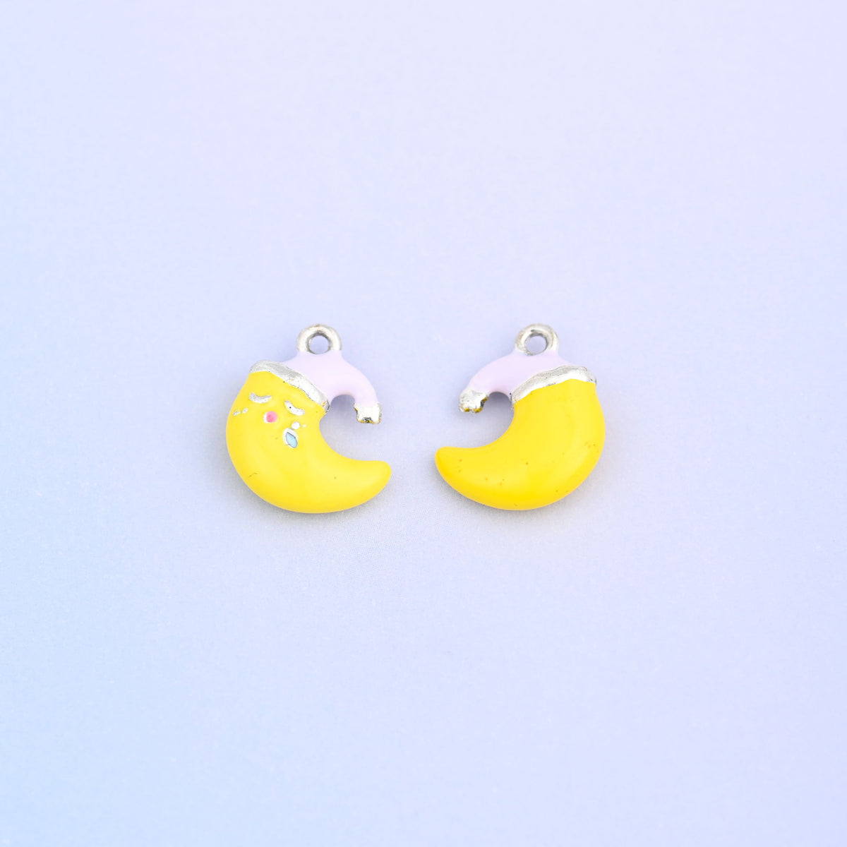Yellow crescent moon charm in a light purple Santa hat, front and back.