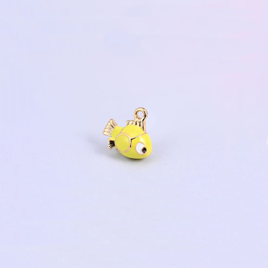 Fish charm tilted forward, gold plated tail and side fins against the yellow green enamel body.