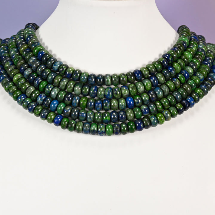 Multi-strand Phoenix Lapis necklace laid flat on a mannequin neck form against a lavender background.