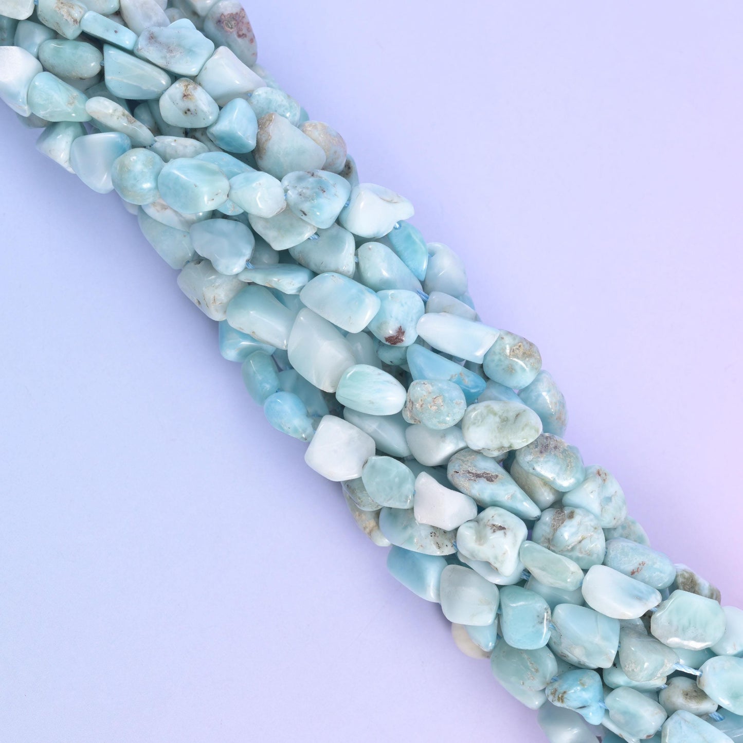 Strands running off at an angle, blue and near-white beads alternating along the cord