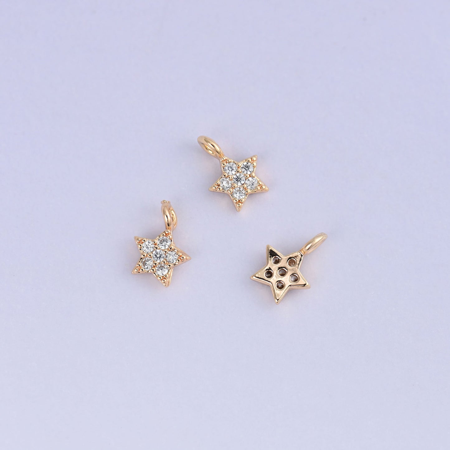 Small gold charms, three star charms with one turned to show the back