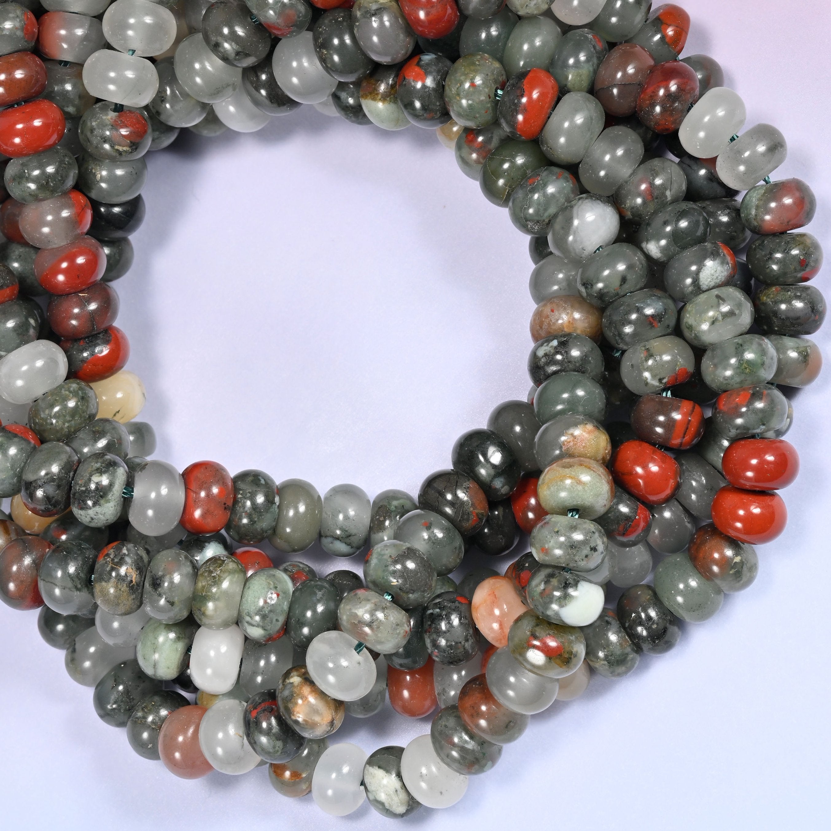 Close-up horizontal row of African Bloodstone beads showing the gray-green and red stone pattern.
