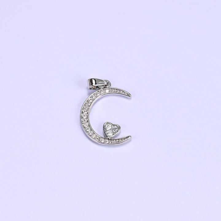 Moon heart zirconia charm in silver tone, a single crescent moon pendant paved with clear stones and a small heart in the curve.