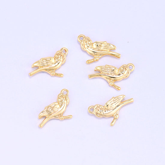 Small gold charms bird, five 18K gold plated bird charms grouped on a lilac backdrop