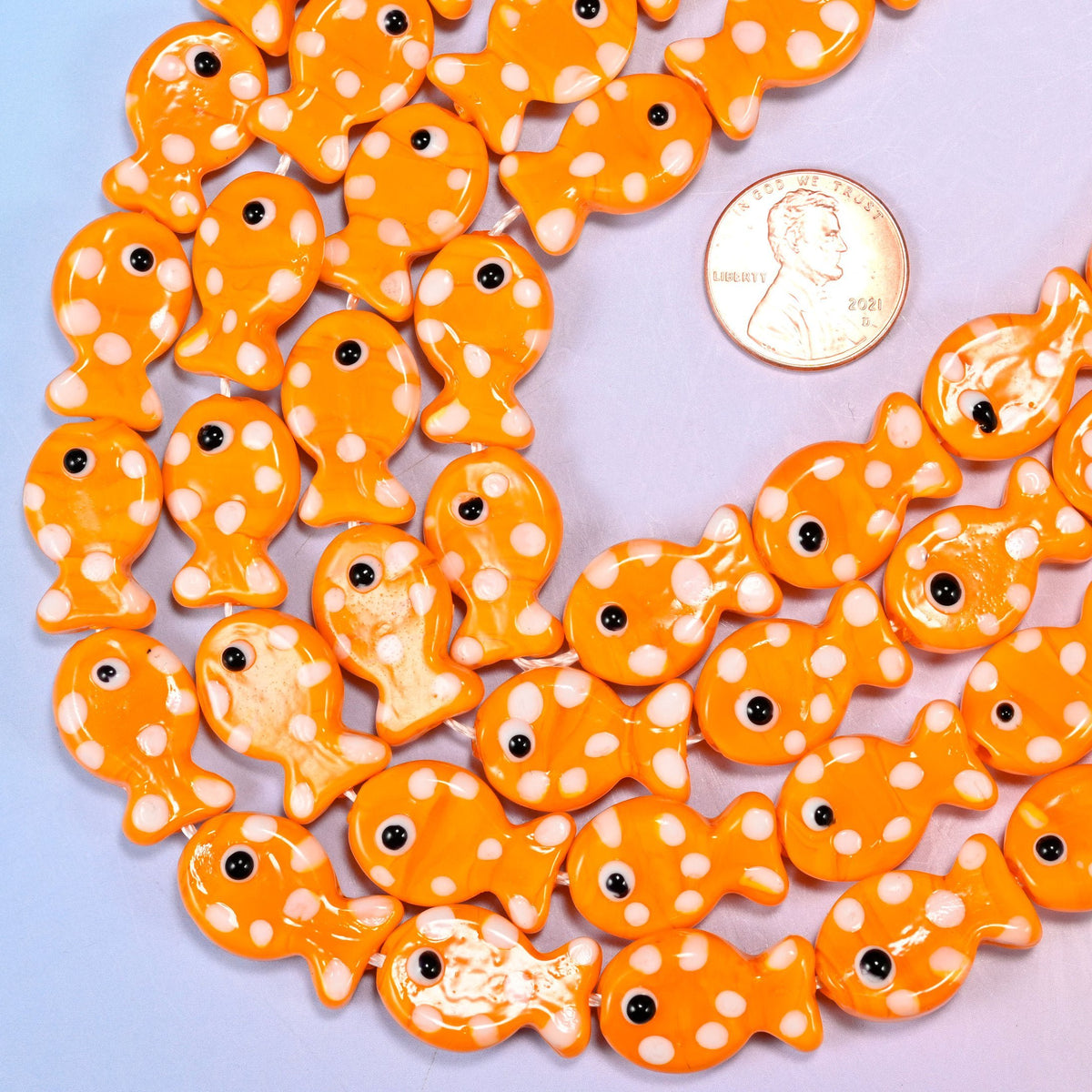 Fish-shaped orange glass beads with white dot pattern