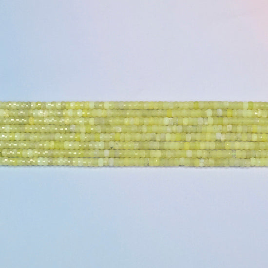 Several strands of Lemon Jade faceted heishi disc beads laid in straight rows