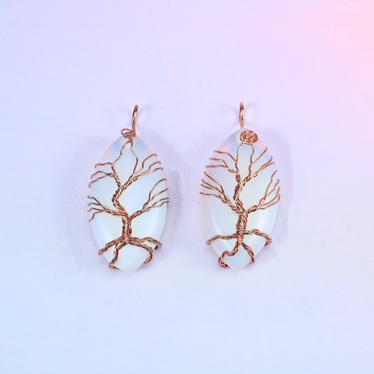 Oval Crystal Pendant with Copper Wired Tree in milky opalescent white, a pair showing the fine copper branch work across the light surface.