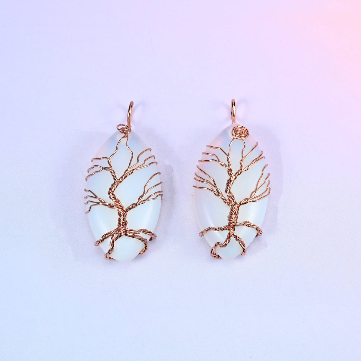 Oval Crystal Pendant with Copper Wired Tree in milky opalescent white, a pair showing the fine copper branch work across the light surface.