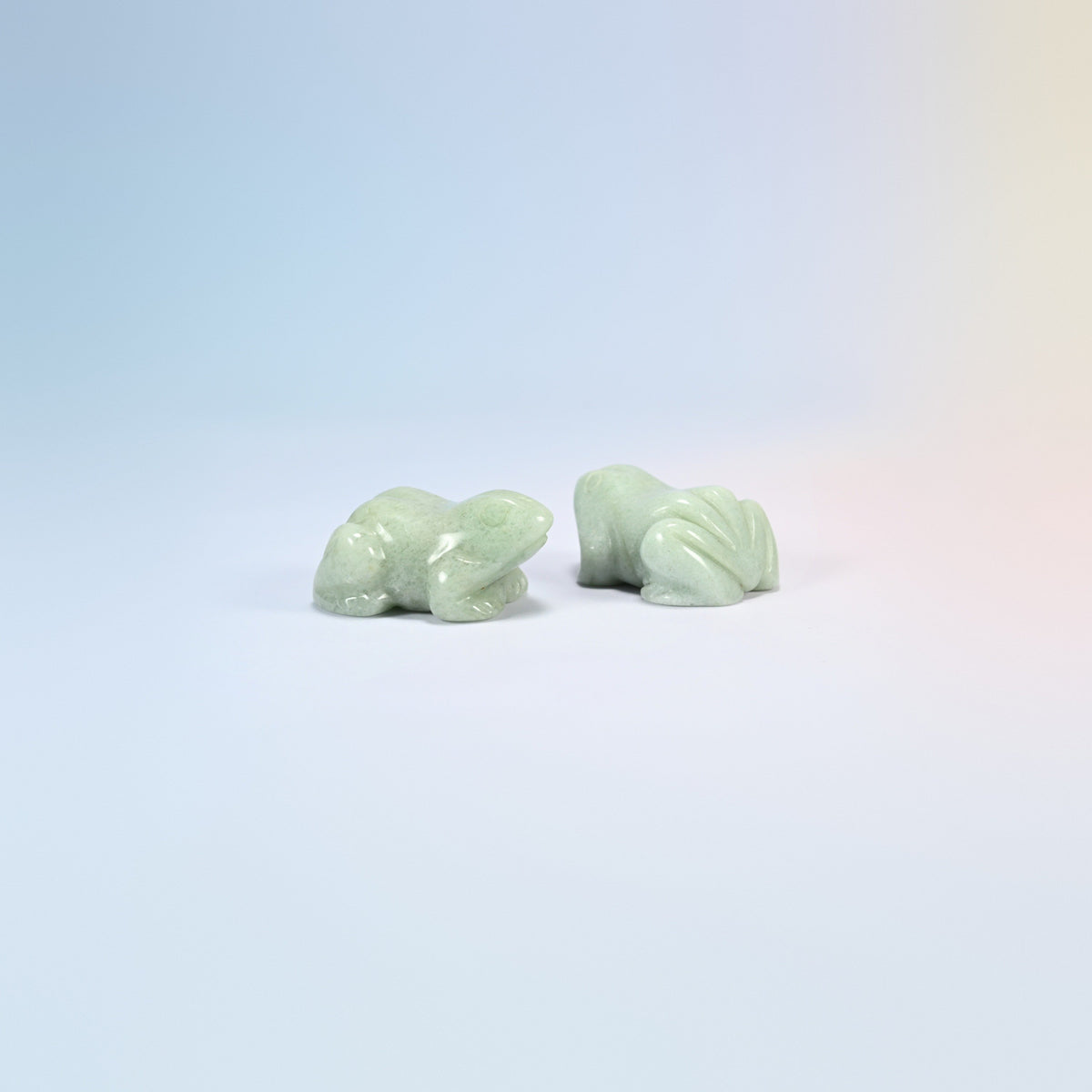 Two natural green aventurine frog carvings, soft green polished stone