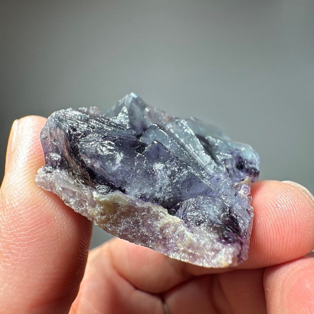 Side view of the Fluorite and calcite specimen against a soft grey background