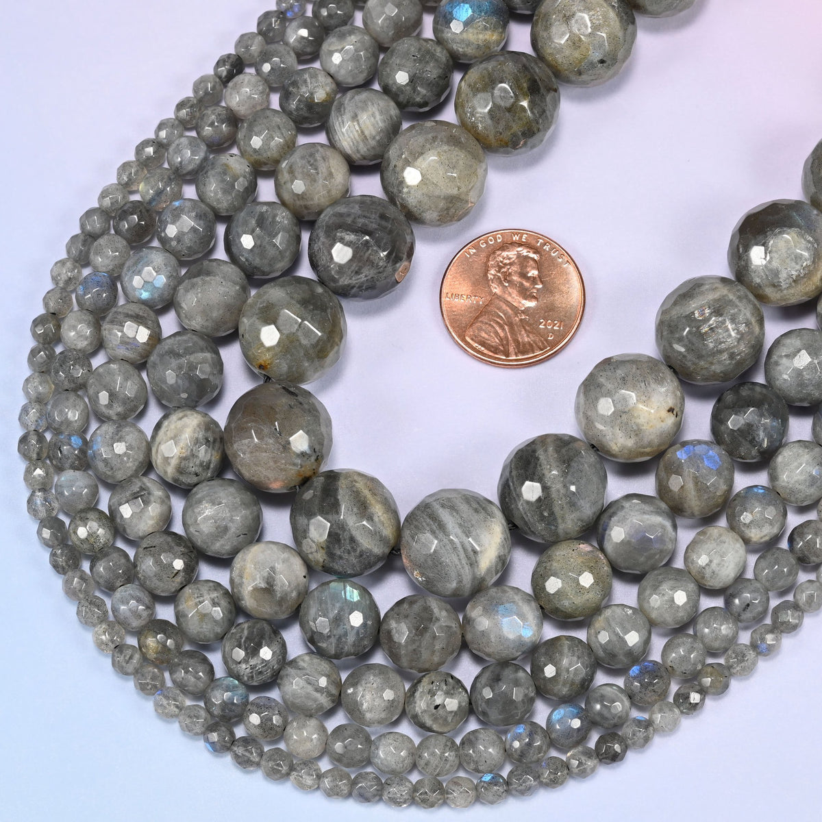 Gray Labradorite faceted round beads in a deep loop, shown at their true size of 4mm to 14mm